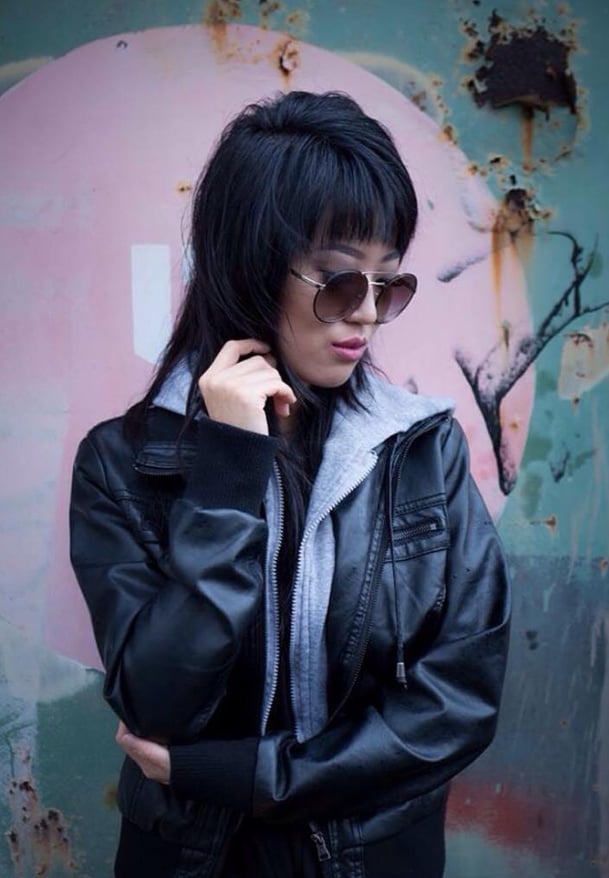 MinJi Pae UGC model content creator wearing sunglasses and a black leather jacket standing in front of a graffiti wall 